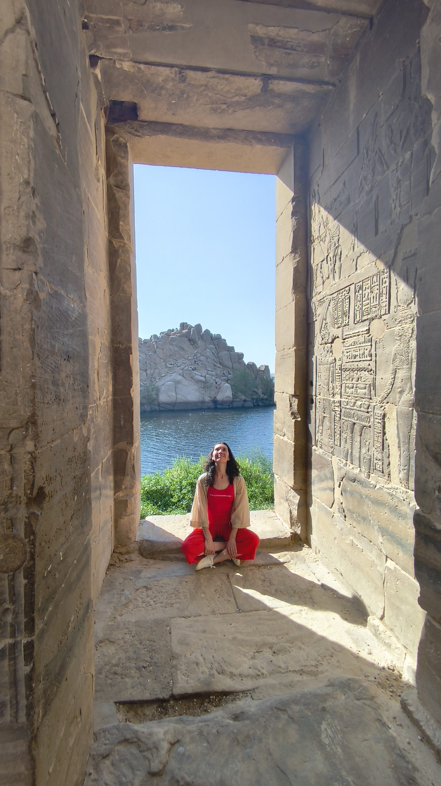Una viajera sentada en el umbral de un templo de Philae, con el Nilo enmarcado por la puerta