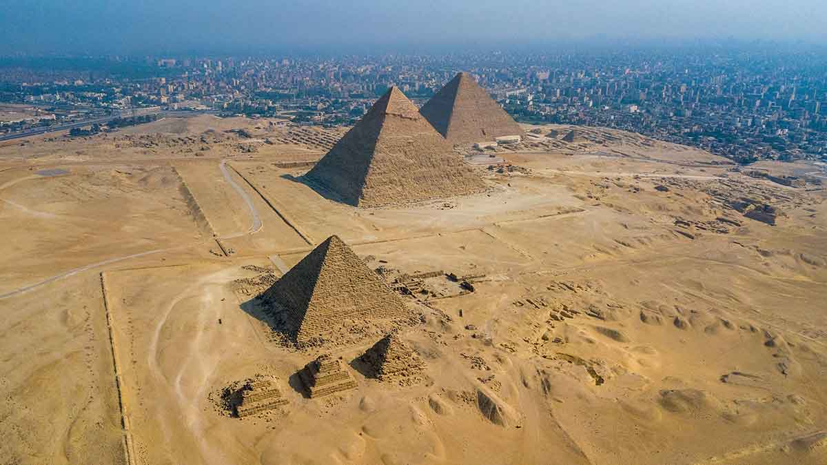 Una viajera frente a la Esfinge y la pirámide de Kefrén, en Giza